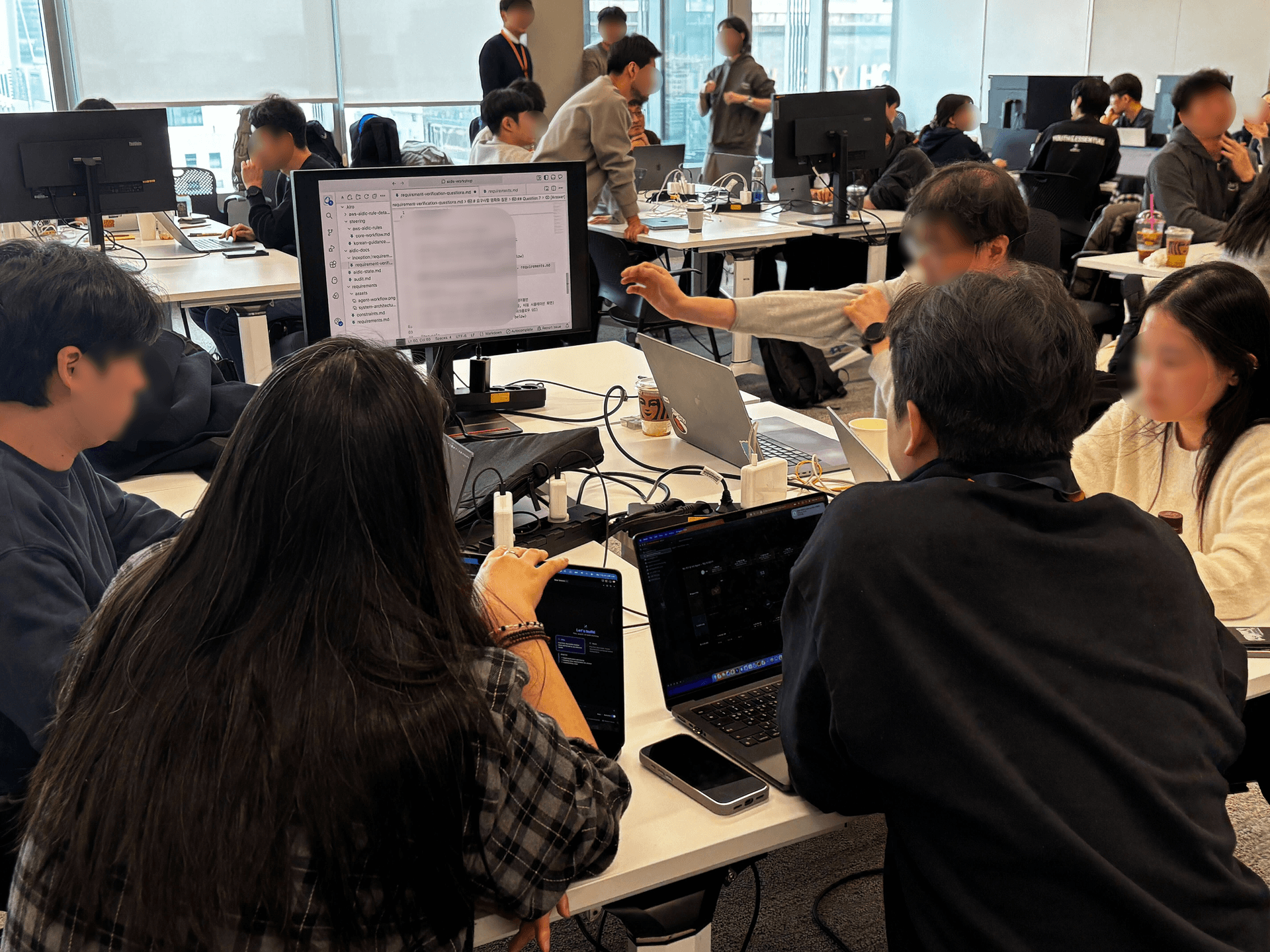 외부 모니터에 설계 문서를 띄워놓고 팀원들이 토론하는 모습
